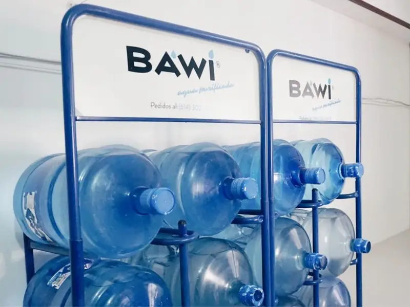 Garrafones nuevos en rejilla con el logotipo de Bawi Agua Purificada